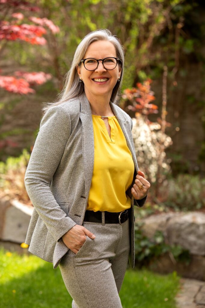 Birgit Strasser-Jentsch steht lächelnd im Garten